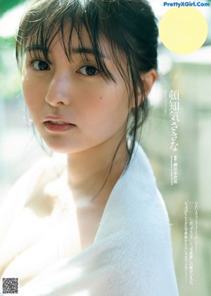 A young woman with long black hair wrapped in a towel.