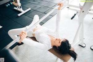A woman sitting on a stationary bike in a gym.