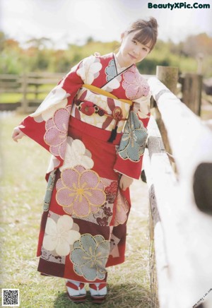 A woman in a kimono sitting on a green couch.