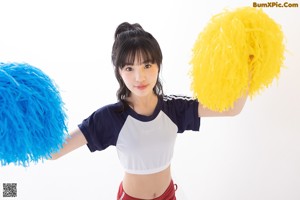 A young woman holding a soccer ball in her hand.