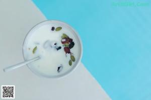 A woman in a pink lingerie sitting by a pool.