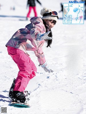 A woman laying in the snow with her feet up in the air.