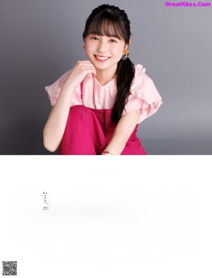 A woman in a pink dress posing for a picture.