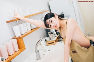 A woman sitting on a chair in a kitchen.