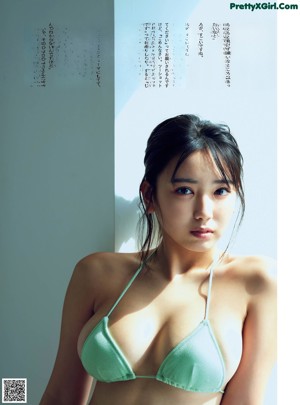 A woman in a bikini sitting on the floor.
