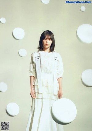 A woman with long black hair wearing a white shirt.