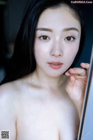 A naked woman standing in a bathroom next to a shower.