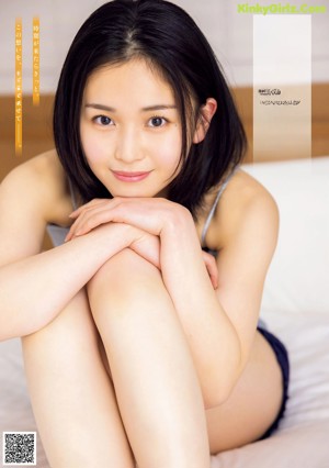 A woman laying on top of a bed smiling.