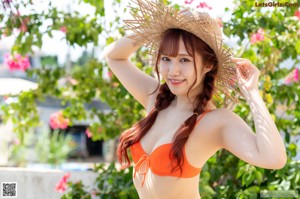A woman in an orange bikini standing on a set of stairs.