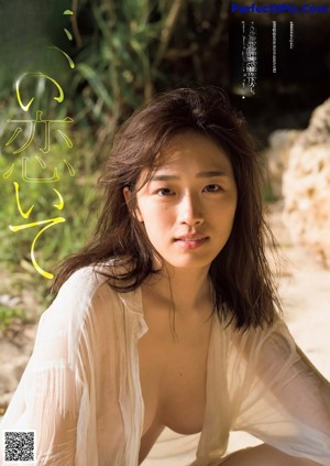 A naked woman standing in the middle of a forest.