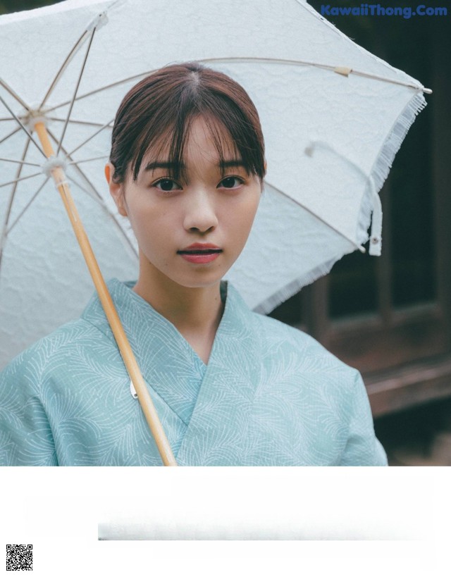 A woman in a kimono holding an umbrella.