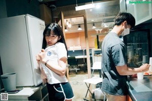 A woman sitting on a chair in front of a coffee machine.