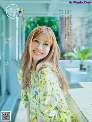 A woman with long brown hair is looking at the camera.