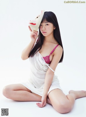 A woman in a white bodysuit holding a red bag.