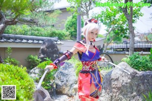 A woman in a red and blue outfit holding a sword.