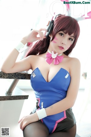A woman in a blue dress with bunny ears on her head.