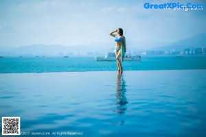 A woman standing on the deck of a boat in the ocean.