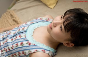 A young girl laying on a bed with a teddy bear.