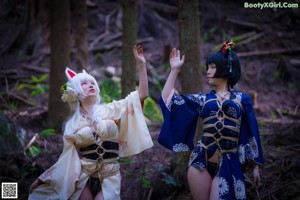 A woman in a kimono is posing in the woods.