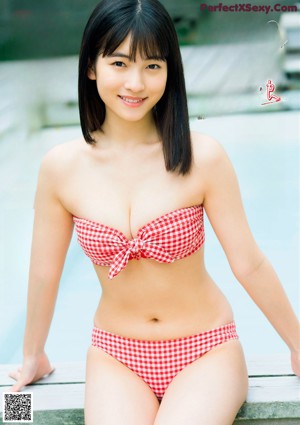 A woman in a white bikini standing on a beach.