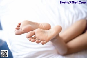 A woman in a purple lingerie laying on a bed.