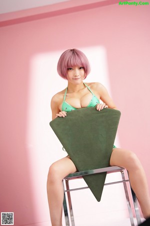 A woman in a green bikini laying on a bed.