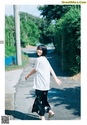 A woman with long black hair and a white shirt.