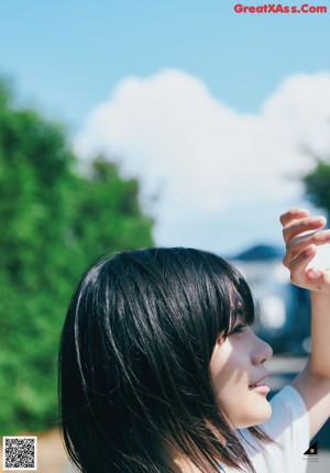 A woman with long black hair looking up at the sky.